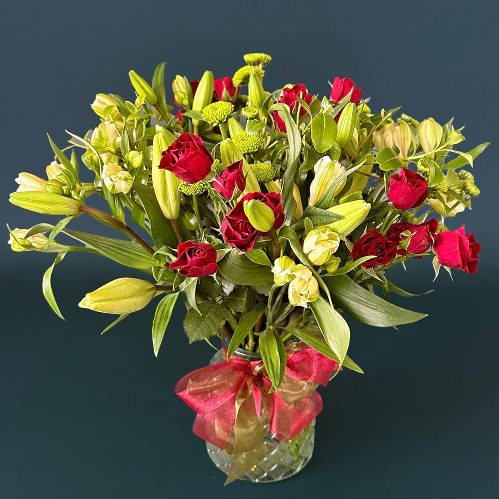 Festive Seasonal Vase featuring red, white and green Christmas flowers arranged in a premium glass vase